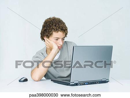 Young man using laptop and wireless mouse View Large Photo Image Stock Image - Young man using laptop and wireless mouse. Fotosearch