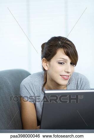 Stock Photograph - Young woman using laptop. Fotosearch