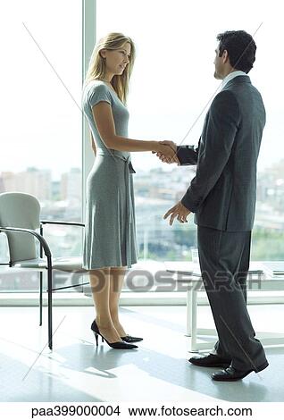 Businessman shaking hands with woman in lobby View Large Photo Image Picture - Businessman shaking hands with woman in lobby. Fotosearch