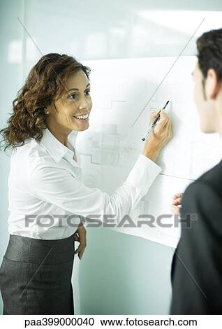 Female architect pointing to blueprints with pen, smiling at client View Large Photo Image Stock Image - Female architect pointing to blueprints with pen, smiling at client. Fotosearch