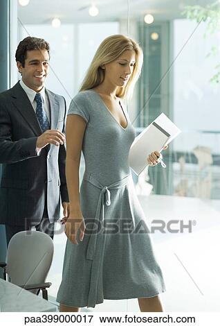 Stock Photo - Professional man and woman stepping away from table. Fotosearch