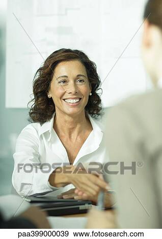 Professional woman shaking hands with second woman View Large Photo Image Stock Photo - Professional woman shaking hands with second woman. Fotosearch