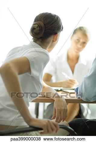 Professional woman sitting at table across from second woman, rear view View Large Photo Image Stock Photo - Professional woman sitting at table across from second woman, rear view. Fotosearch