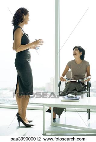 Two women talking in lobby View Large Photo Image Stock Image - Two women talking in lobby. Fotosearch