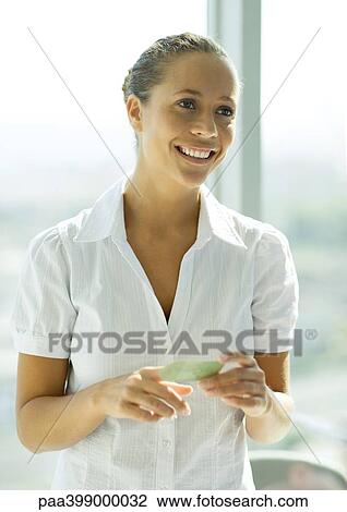 Woman holding business card, smiling View Large Photo Image Stock Image - Woman holding business card, smiling. Fotosearch