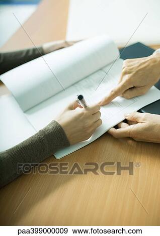 Stock Photo - Woman signing contract, close-up of hands. Fotosearch