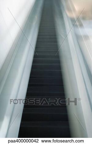 Stock Image - Escalator, blurred, low angle view. Fotosearch