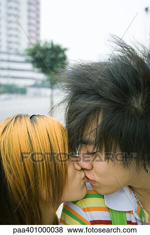 Stock Photo - Teenage couple kissing in urban setting. Fotosearch