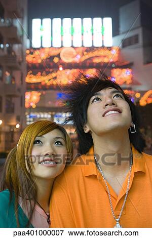 Teenage couple looking up, lights in background View Large Photo Image Stock Photo - Teenage couple looking up, lights in background. Fotosearch