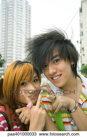 Stock Image - Teenage couple making peace signs. Fotosearch
