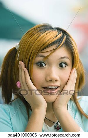 Teenage girl holding head, looking at camera View Large Photo Image Stock Photograph - Teenage girl holding head, looking at camera. Fotosearch