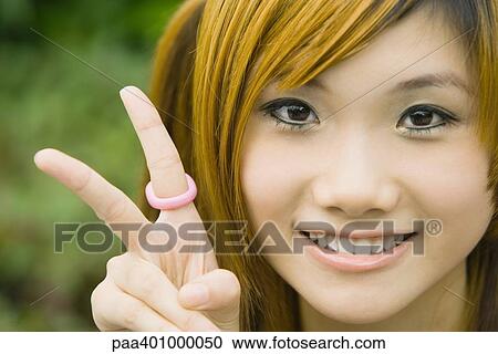 Teenage girl making peace sign, portrait View Large Photo Image Stock Image - Teenage girl making peace sign, portrait. Fotosearch