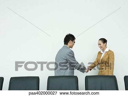 Stock Photo - Businessman and businesswoman shaking hands. Fotosearch