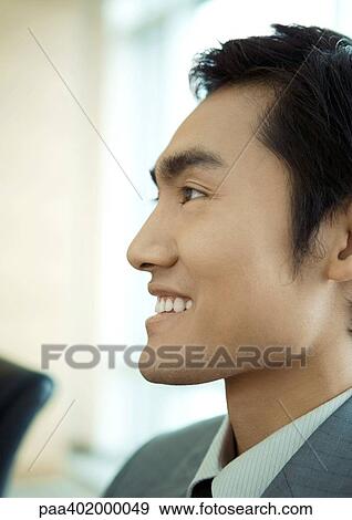 Businessman smiling, close-up side view of face View Large Photo Image Stock Photo - Businessman smiling, close-up side view of face. Fotosearch