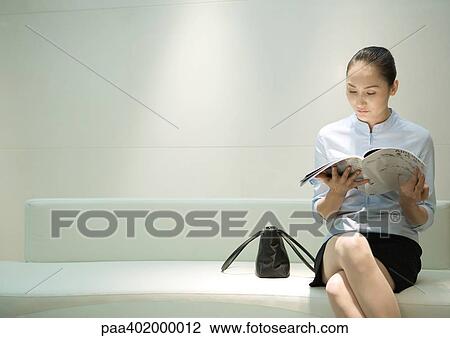 Businesswoman sitting, reading magazine in waiting room View Large Photo Image Stock Image - Businesswoman sitting, reading magazine in waiting room. Fotosearch