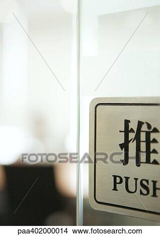 Picture - Push sign on door in English and Chinese. Fotosearch