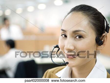 Woman wearing headset, smiling at camera View Large Photo Image Stock Photo - Woman wearing headset, smiling at camera. Fotosearch