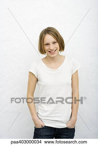 Picture - Teenage girl with hands in pockets, front view. Fotosearch