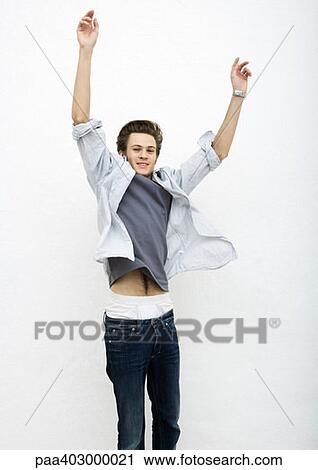 Young man jumping with arms in air View Large Photo Image Stock Image - Young man jumping with arms in air. Fotosearch