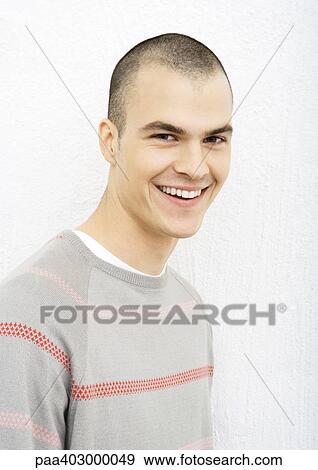 Stock Photo - Young man smiling at camera, portrait. Fotosearch