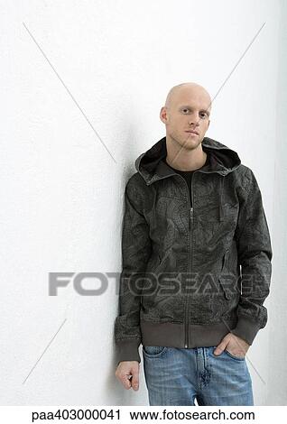 Stock Image - Young man standing with hand in pocket, front view, portrait. Fotosearch
