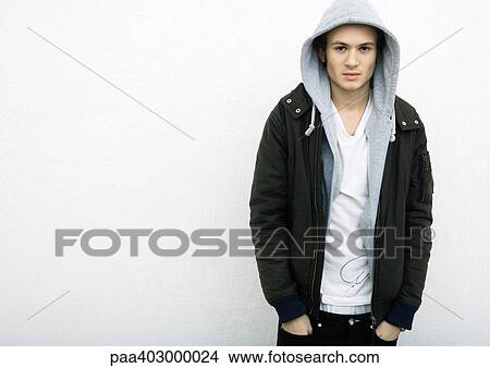 Young man standing with hands in pockets View Large Photo Image Picture - Young man standing with hands in pockets. Fotosearch