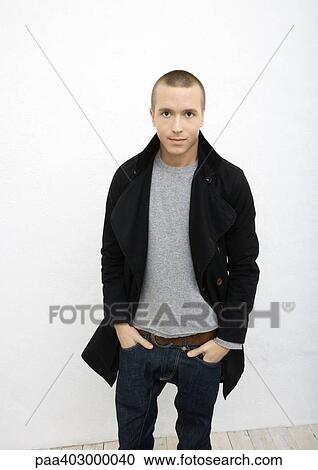 Young man standing with hands in pockets, front view, portrait View Large Photo Image Stock Image - Young man standing with hands in pockets, front view, portrait. Fotosearch