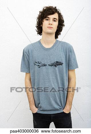 Young man standing with hands in pockets, front view, portrait View Large Photo Image Stock Photograph - Young man standing with hands in pockets, front view, portrait. Fotosearch