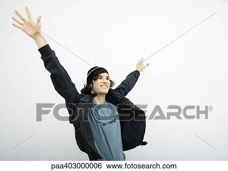 Stock Photograph - Young man standing with hands up in air. Fotosearch