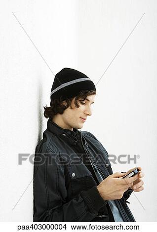 Picture - Young man using cell phone. Fotosearch