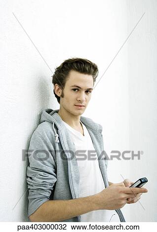 Young man using cell phone View Large Photo Image Stock Image - Young man using cell phone. Fotosearch