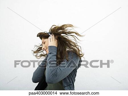 Young woman listening to headphones, white background View Large Photo Image Picture - Young woman listening to headphones, white background. Fotosearch