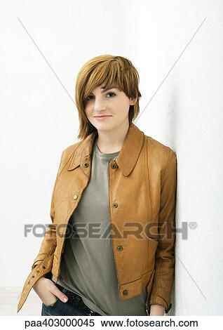 Stock Photography - Young woman standing with hand in pocket, portrait. Fotosearch
