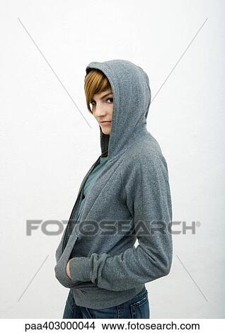 Young woman standing with hands in sweatshirt pockets View Large Photo Image Picture - Young woman standing with hands in sweatshirt pockets. Fotosearch