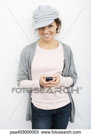 Stock Image - Young woman using cell phone. Fotosearch
