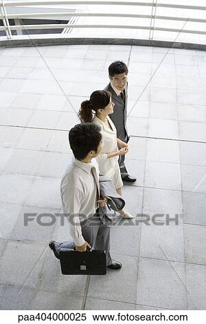 Three young executives walking side by side, high angle view View Large Photo Image Stock Photography - Three young executives walking side by side, high angle view. Fotosearch