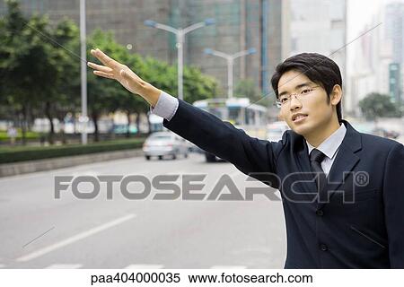 Young businessman hailing at taxi View Large Photo Image Stock Photography - Young businessman hailing at taxi. Fotosearch