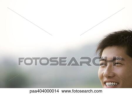 Picture - Young man smiling, cropped view of face. Fotosearch