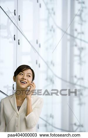 Stock Image - Young woman using cell phone. Fotosearch