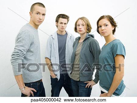 Stock Image - Group of young adults standing with hands on hips, looking at camera. Fotosearch
