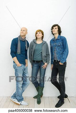 Group of young adults standing with hands in pockets, looking away, full length View Large Photo Image Stock Photo - Group of young adults standing with hands in pockets, looking away, full length. Fotosearch