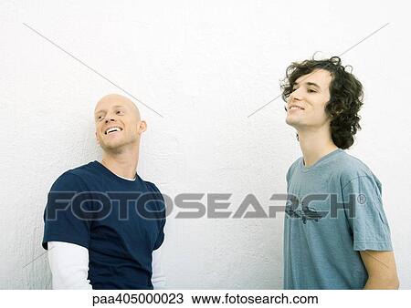 Two young men wearing tee-shirts, looking out of frame, waist up View Large Photo Image Stock Image - Two young men wearing tee-shirts, looking out of frame, waist up. Fotosearch