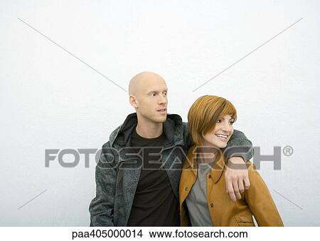 Young couple, man with arm around woman's shoulder, both looking away View Large Photo Image Picture - Young couple, man with arm around woman's shoulder, both looking away. Fotosearch