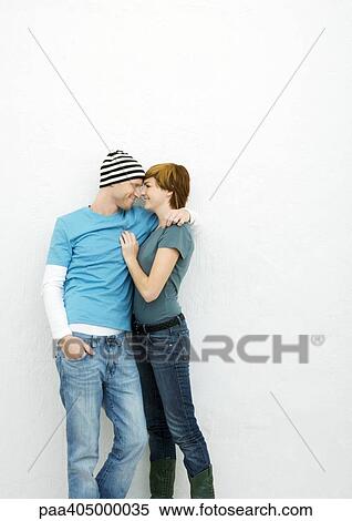 Young couple standing face to face, smiling at each other, three quarter length View Large Photo Image Stock Photography - Young couple standing face to face, smiling at each other, three quarter length. Fotosearch