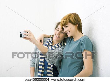 Young female friends, taking photo together View Large Photo Image Picture - Young female friends, taking photo together. Fotosearch
