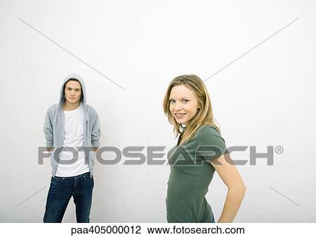 Young woman and young man, standing apart, both looking at camera View Large Photo Image Stock Image - Young woman and young man, standing apart, both looking at camera. Fotosearch