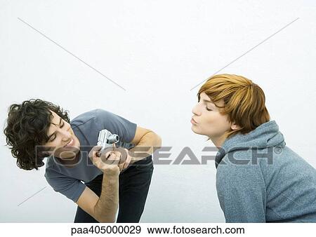 Young woman puckering while young male friend takes photo View Large Photo Image Stock Photo - Young woman puckering while young male friend takes photo. Fotosearch