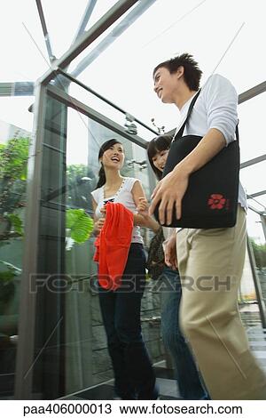 Friends in covered walkway, chatting, low angle view View Large Photo Image Stock Image - Friends in covered walkway, chatting, low angle view. Fotosearch