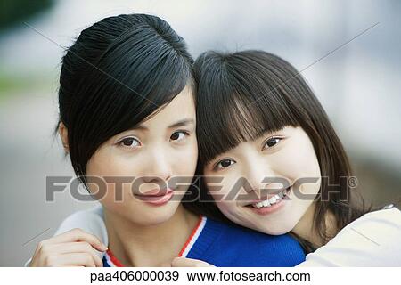 Two female friends, one with arms around the other's shoulders View Large Photo Image Stock Photo - Two female friends, one with arms around the other's shoulders. Fotosearch