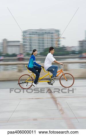 Young couple riding tandem bicycle View Large Photo Image Stock Image - Young couple riding tandem bicycle. Fotosearch